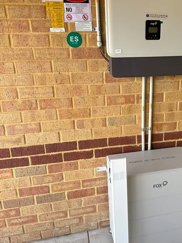 Fox ESS battery and inverter installed on a red brick wall