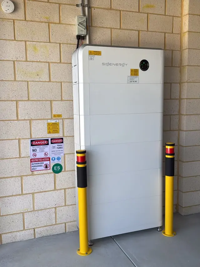 Sigenergy battery system installed in a garage with safety bollards